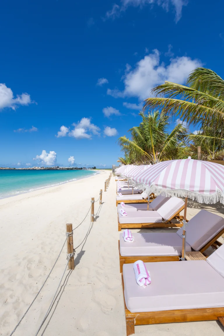 Pink-cushioned sunbeds and white parasols on Simpson Bay beach